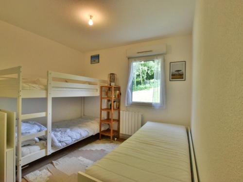 una camera da letto con due letti a castello e una finestra di Appartement spacieux avec piscine, balcon, parking et wifi à Publier - FR-1-498-99 a Publier