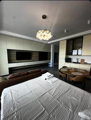 a bedroom with a large bed and a dining room at Axxis Luxury Studio in Mamaia