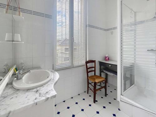 a white bathroom with a sink and a chair at Villa au Calme avec Jardin, Proche Plage et Commerces, Wifi et Équipements Complets - FR-1-361-117 in Jullouville-les-Pins