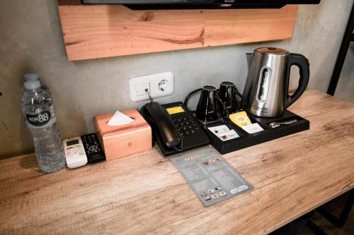 a counter top with a coffee maker and a phone at Hotel Summerville in Majalengka