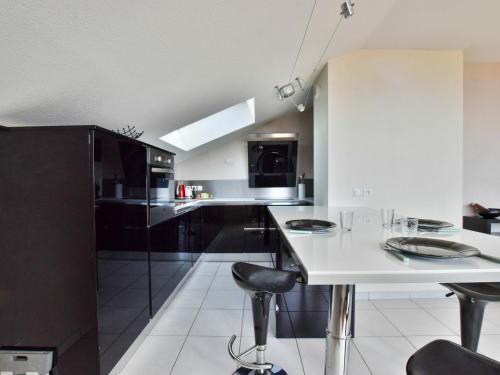 une cuisine avec un comptoir blanc et des appareils noirs dans l'établissement Spacieux appartement avec terrasse, animaux admis et parking - FR-1-498-69, à Évian-les-Bains