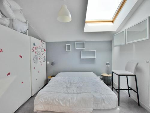 ein Schlafzimmer mit einem weißen Bett und einem Dachfenster in der Unterkunft Spacieux appartement avec terrasse, animaux admis et parking - FR-1-498-69 in Évian-les-Bains