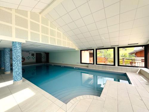 - une grande piscine dans une grande pièce dotée de fenêtres dans l'établissement Appartement cosy avec piscine, animaux admis et parking à Flumet - FR-1-505-206, à Flumet