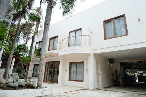 a white house with palm trees in front of it at Frania Boutique Hotel in San Juan