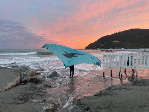 a person holding a blue kite on the beach at La Gio del Fosso in Ameglia