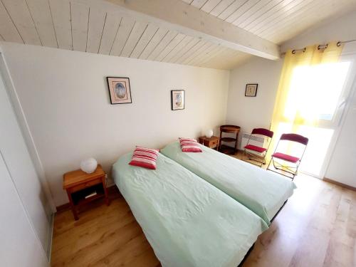 une chambre avec un lit avec deux oreillers dessus dans l'établissement Appartement 2 pièces face mer avec balcon, parking et WIFI – Les Sables-d’Olonne - FR-1-92-941, à Les Sables-dʼOlonne