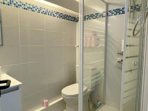 une salle de bain avec toilettes et douche en verre dans l'établissement Appartement 2 pièces avec piscine et parking, accès direct plage - FR-1-748-27, à Canet