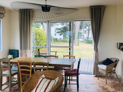une salle à manger avec une table et des chaises en bois dans l'établissement Maison calme 8-9 pers, 4 ch, jardin près du Logeo - FR-1-639-95, à Sarzeau