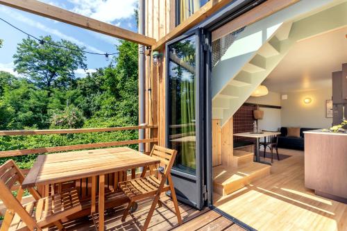 une terrasse ouverte avec une table et des chaises en bois sur une maison dans l'établissement L'Observatoire Sauvage - Amboise, à Amboise