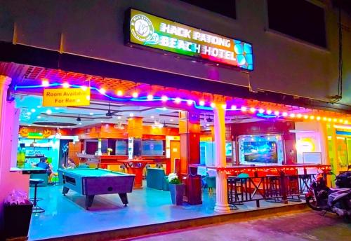 a restaurant with a ping pong table and neon lights at Hack Patong Beach Hotel in Patong Beach