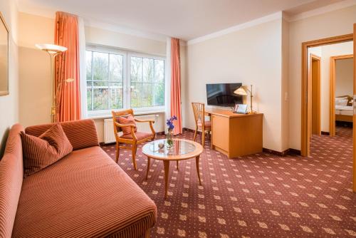 a living room with a couch and a table at Hotel Inselfriede in Spiekeroog