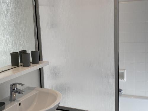 a bathroom with a sink and a glass shower door at Villa avec Jardin à Cabourg, Proche Plage et Centre - FR-1-487-324 in Cabourg