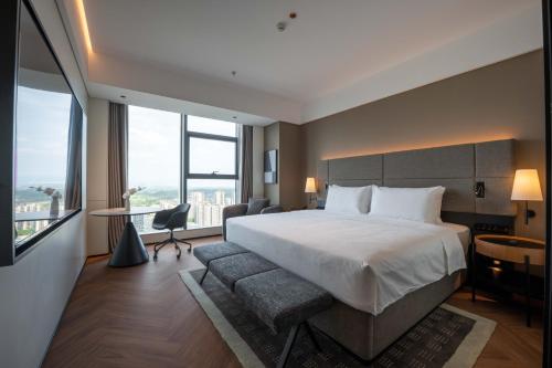 a hotel room with a bed and a large window at IntercityHotel Chengdu New Exhibition Center in Chengdu