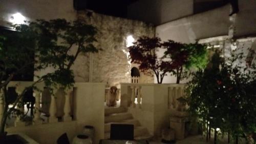 a room with potted trees and a stone wall at Palazzo Muro Leccese Relais de Charme & Wellness in Muro Leccese