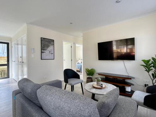 a living room with a couch and a table at S&N modern 2 bedrooms house opposite Waikato Hospital in Hamilton