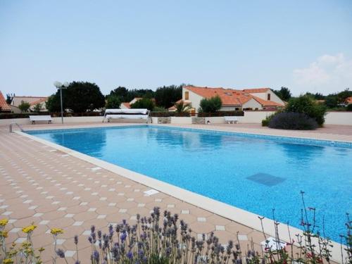 une grande piscine bleue dans une cour dans l'établissement Maison de vacances avec piscine chauffée à 800m de la plage - FR-1-231-315, à Brem-sur-Mer