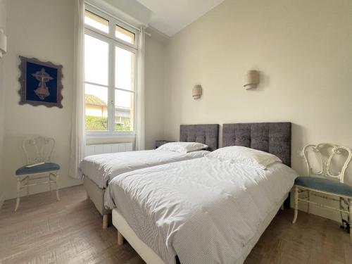 - 2 lits dans une chambre blanche avec fenêtre dans l'établissement Arcachon : Appartement 8 pers, proche plage, jardin, parking, wifi - FR-1-474-275, à Arcachon