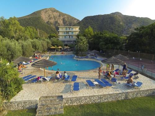 a group of people sitting around a swimming pool at Florida Blue Bay Resort & Spa in Psathopirgos