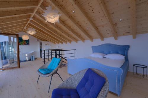 a bedroom with a blue bed and a chair at Villa Biankura in Blato