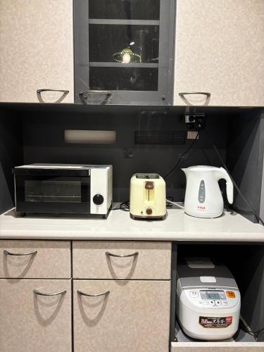 a kitchen with a microwave and a toaster oven on a counter at Vineyard Vista ENZAN in Koshu