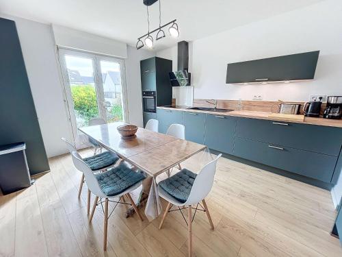- une cuisine avec une table à manger et des chaises dans l'établissement Maison à 500m de la plage avec jardin, 4 chambres, Wi-Fi et parking - 8 couchages - FR-1-361-539, à Saint-Pair-sur-Mer