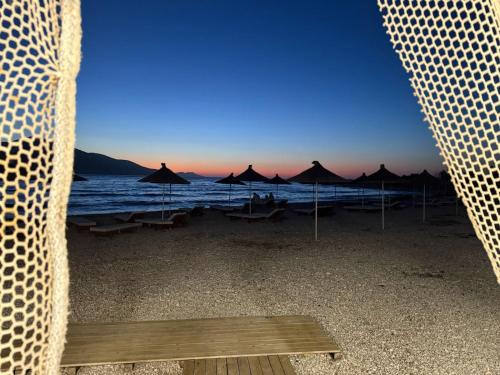 a view of a beach with umbrellas and the ocean at Nettuno Resort Orikum in Orikum
