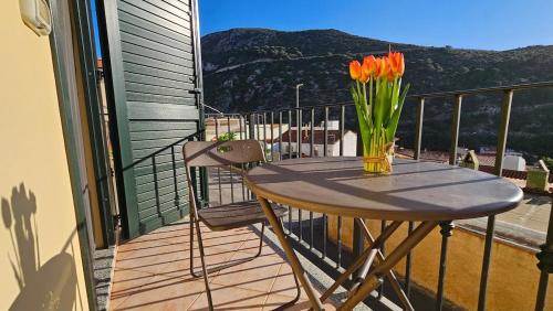 a table with a vase of flowers on a balcony at Buggerru Sunset Home in Buggerru