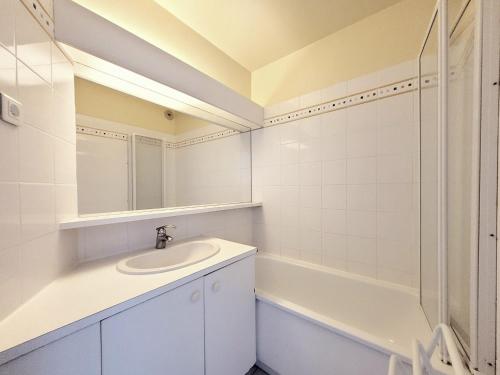 La salle de bains blanche est pourvue d'un lavabo et d'une baignoire. dans l'établissement Canet - T2 cabine 5 pers, accès plage, piscine, parking - FR-1-794-118, à Canet