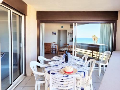 une salle à manger avec une table et une vue sur l'océan dans l'établissement Canet - T2 cabine 5 pers, accès plage, piscine, parking - FR-1-794-118, à Canet