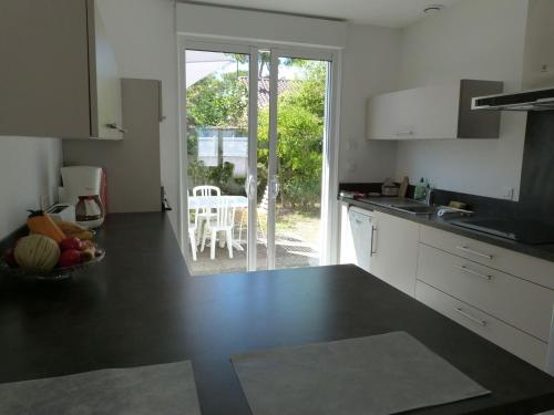 une cuisine avec un comptoir et une table avec une chaise dans l'établissement Maison Rénovée pour 7 Personnes à 350m de la Plage, Jardin Clos, Confort Moderne - FR-1-194-245, à La Tranche-sur-Mer