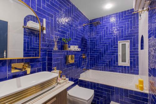 un bagno piastrellato blu con un water e un lavandino di SaffronStays Rang Havelii - Luxurious Premium Rajasthani art-themed stay with City Palace views a Udaipur