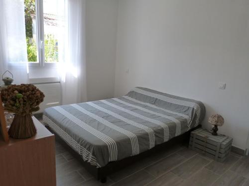 un lit dans une chambre blanche avec une fenêtre dans l'établissement Maison Rénovée pour 7 Personnes à 350m de la Plage, Jardin Clos, Confort Moderne - FR-1-194-245, à La Tranche-sur-Mer