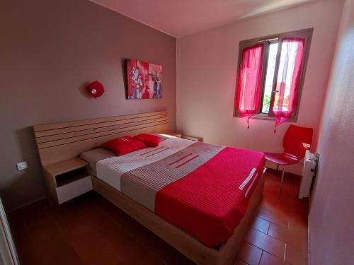 - une chambre avec un lit doté de draps rouges et une fenêtre dans l'établissement Appartement 2 pièces avec piscine, tennis et parking, animaux permis, à 500m de la mer - FR-1-776-121, à Argelès-sur-Mer