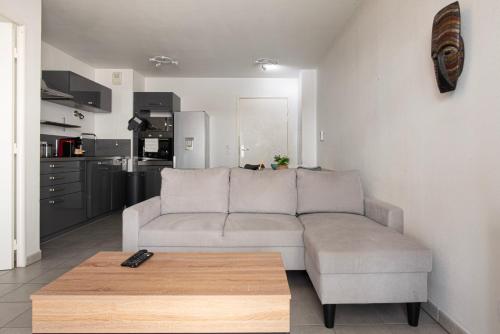 a living room with a couch and a table at Appart Romarin - Proche Gare & Stadium in Miramas