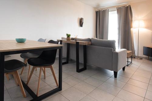 a dining room with a table and a chair and a table and chairsktop at Appart Romarin - Proche Gare & Stadium in Miramas