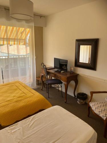 une chambre avec un bureau avec un ordinateur dessus dans l'établissement Hôtel Restaurant Brasilia, à Cagnes-sur-Mer