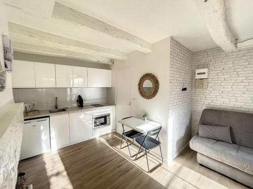 une cuisine et un salon avec une table et un canapé dans l'établissement Charmant studio refait à neuf avec terrasse - animaux admis, Wi-Fi gratuit - FR-1-361-562, à Granville