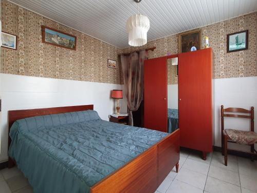 une chambre avec un lit et une armoire rouge dans l'établissement Appartement RDC Centre Aiguillon-sur-Mer, Proche Marché, Plages et Commerces, 4 Pers, Animaux Ok - FR-1-476-209, à LʼAiguillon-sur-Mer