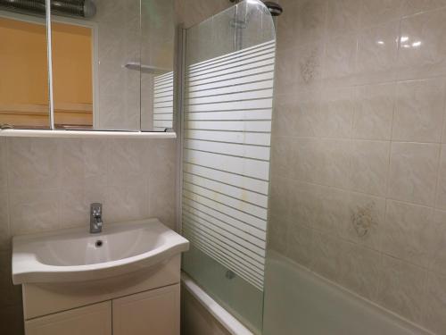 une salle de bain avec un lavabo et une douche en verre dans l'établissement Appartement RDC avec Terrasse, Piscine & Accès Plage - St Cyprien, 4 Couchages - FR-1-753-27, à Saint-Cyprien