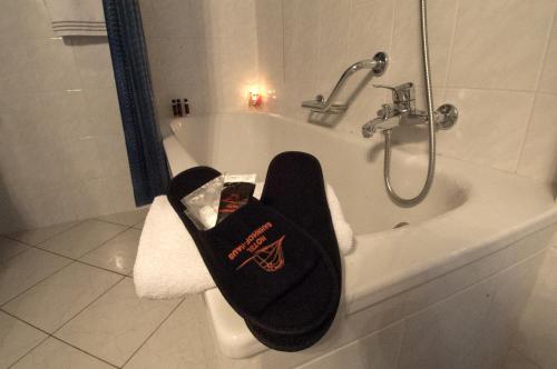 a bathroom with a bath tub with a black towel at Hotel Bahnhof Haus in Chiasso