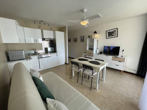un salon avec un canapé et une table et une cuisine dans l'établissement Charmant T2 rénové, 4 couchages, proche plage et port, balcon, parking sécurisé, St-Cyprien - FR-1-106-55, à Saint-Cyprien