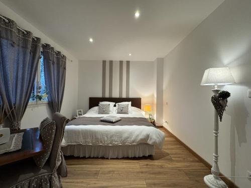 a bedroom with a bed and a lamp and a window at Le Luxury - 24h du Mans - 11pers - Rêve au Mans in Ruaudin