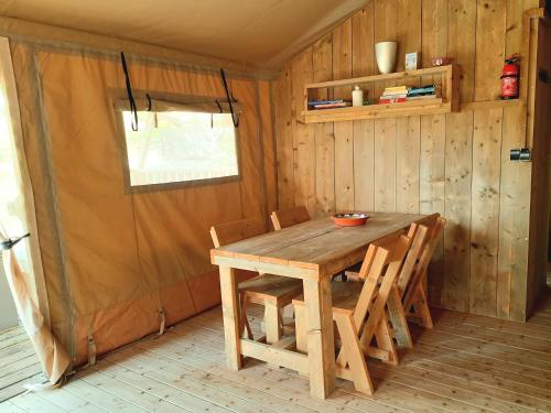 a wooden table and chairs in a room at Silver Coast Glamping luxury lodge in Alcobaça