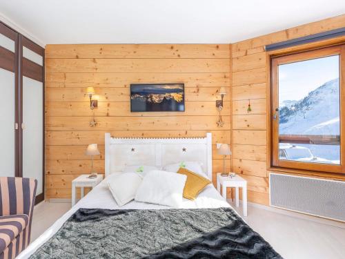 une chambre avec un lit dans une pièce aux murs en bois dans l'établissement Appartement cosy 2 pièces avec balcon, internet et lits faits à l'arrivée - FR-1-314-286, à Morzine