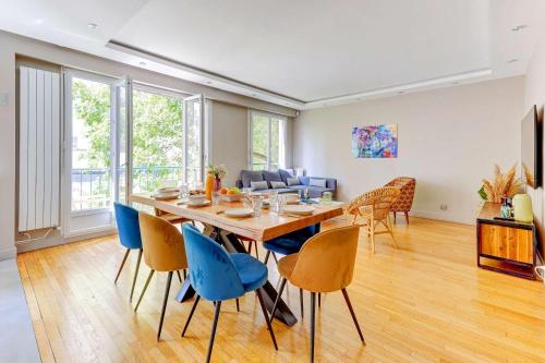 une salle à manger avec une table et des chaises bleues dans l'établissement Appartement chic 82m2 6 pers Paris 16E, à Paris