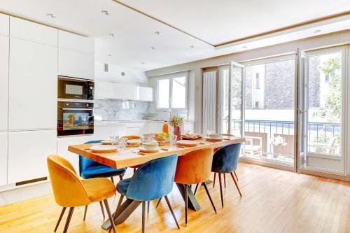 une cuisine avec une grande table et des chaises en bois dans l'établissement Appartement chic 82m2 6 pers Paris 16E, à Paris