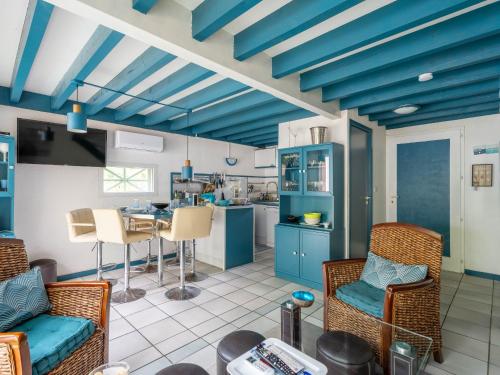 - une cuisine avec des plafonds et des chaises bleus ainsi qu'une table dans l'établissement Maison à Biscarrosse - 4 pers, lac à pied, terrasse, parking - FR-1-319-580, à Biscarrosse