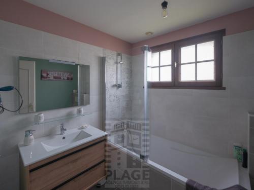 une salle de bain avec un lavabo, une douche et une baignoire dans l'établissement Maison 3 chambres avec piscine privée et jardin clos - FR-1-197-617, à Les Sables-dʼOlonne