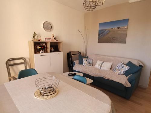un salon avec une table et un canapé dans l'établissement Valras-Plage: Apt 4 pers, clim, parking privé, proche plage - FR-1-781-56, à Valras-Plage