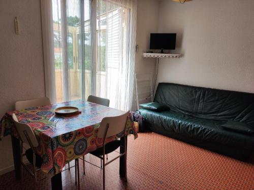un salon avec une table et un canapé dans l'établissement Appartement 2 pièces, 4 pers, proche plage et commerces, parking, animaux admis - FR-1-776-115, à Argelès-sur-Mer